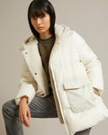 A line down jacket in a mix of technical fabrics with merino shearling hooded bib
